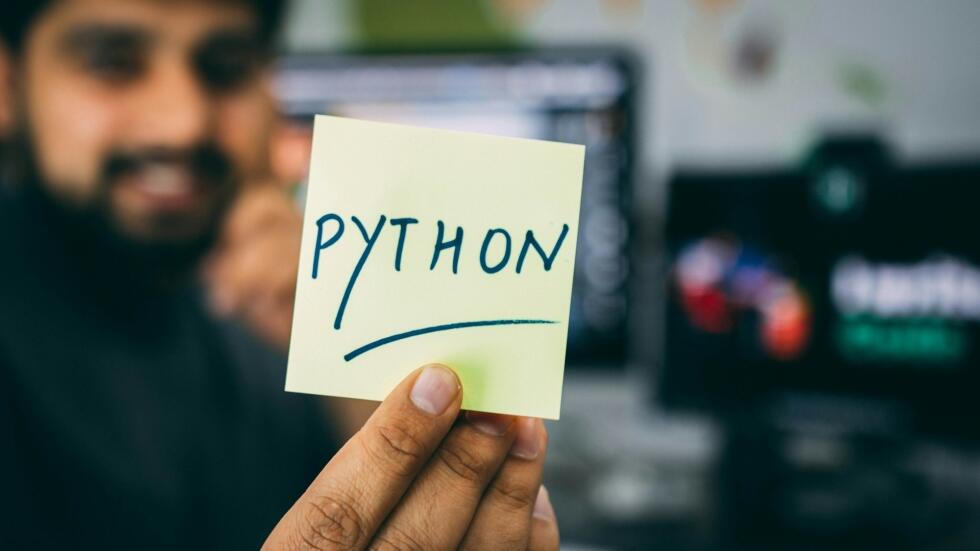 elinde python yazısı tutan bir adam